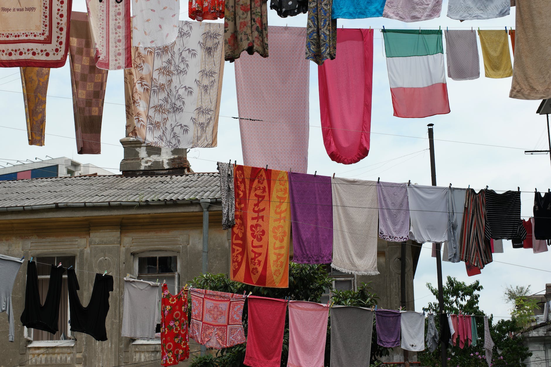 colorful lines of clothing hung up outside between buildings