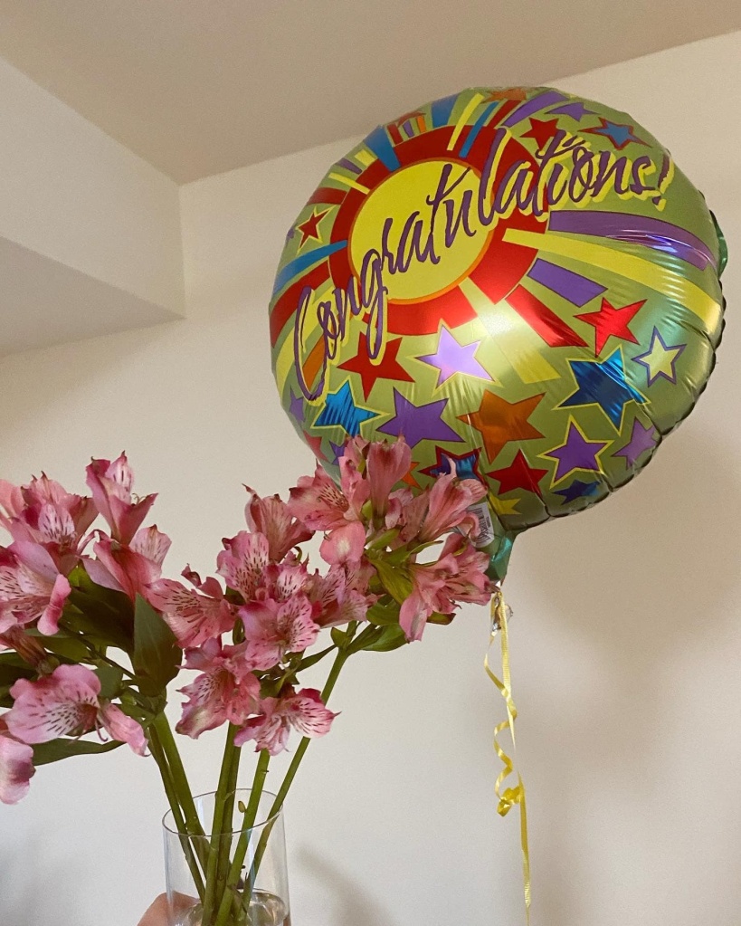 a bouquet of flowers and a "congratulations" balloon